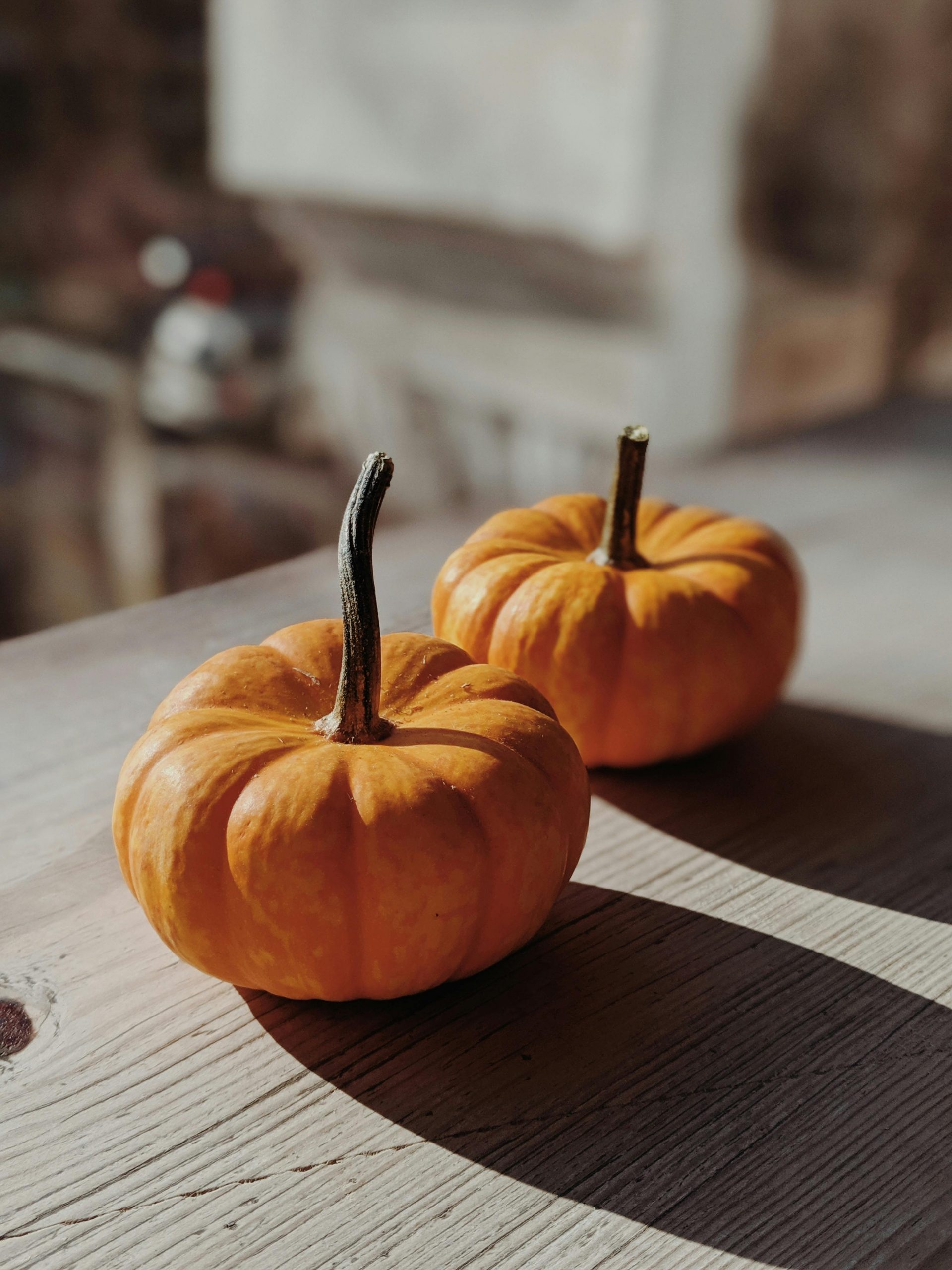 Citrouilles orange de saison posées sur une table en bois, symbole d’automne et d’abondance